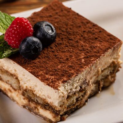 tiramisu cake slice on a plate with garnish