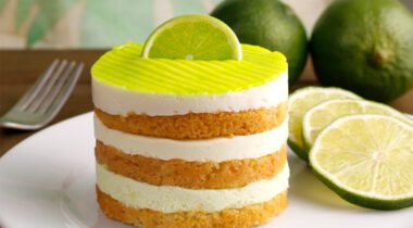 Round cut portion of Key Lime Pie on plate with limes