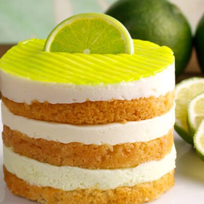 Round cut portion of Key Lime Pie on plate with limes