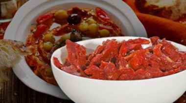 white bowl of sundried tomatoes over tomato soup