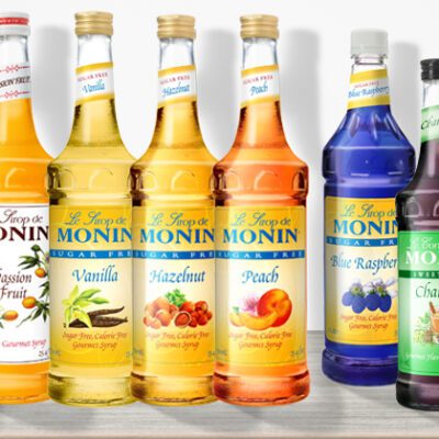 Fourteen bottles of Monin beverage enhancers.