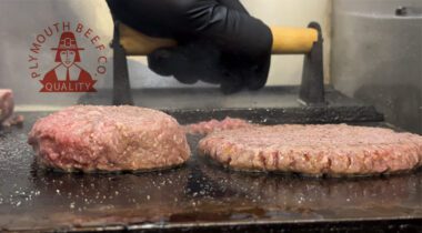 smashed and unsmashed burgers cooking on a grill