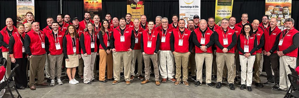 sales team at an event, wearing red vests and black shirts, lanyards with badges
