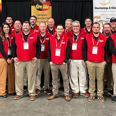 sales team at an event, wearing red vests and black shirts, lanyards with badges
