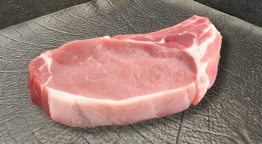 bone-in pork chop on a black plate