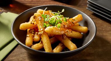 bowl of cheese dipper appetizer with seasonings and herbs on top