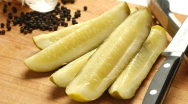 5 slices of pickles on wood cutting board