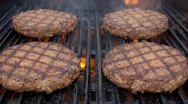 hamburger patties cooking on a char broiler grill