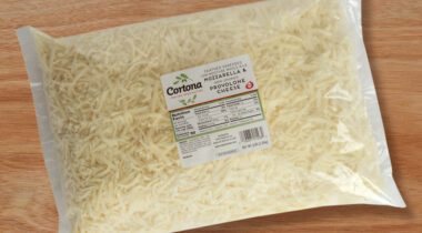 clear bag of shredded white cheese on cutting board