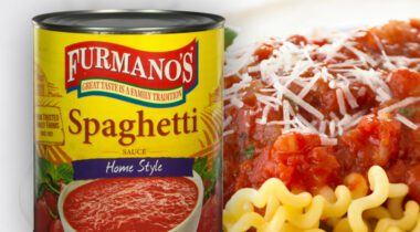 tin can of Spaghetti Sauce over close up of spagetti noodles, red spaghetti sauce and cheese shavings