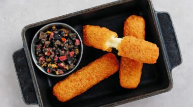 black metal serving plate with three cheese mozzarella sticks