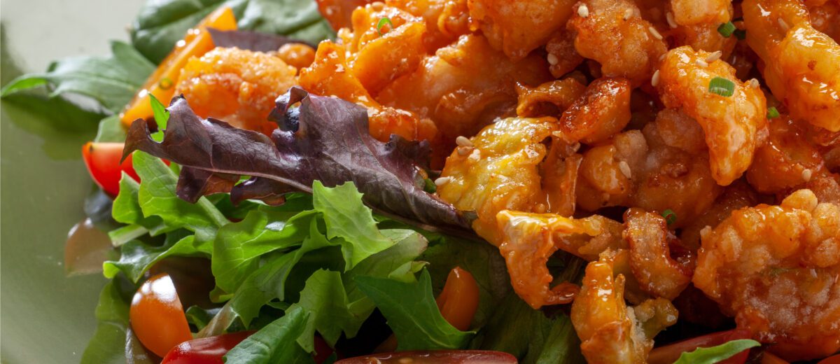 sauce coated fried shrimp and calamari on a bed of lettuce and diced tomatoes.