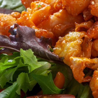 sauce coated fried shrimp and calamari on a bed of lettuce and diced tomatoes.
