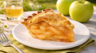 slice of apple pie on a white plate outdoors