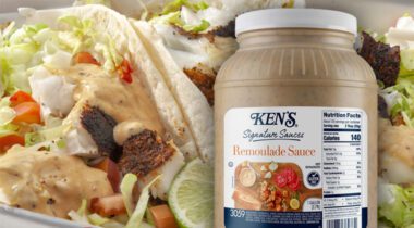 gallon jug of Ken's Remoulade Sauce over prepared tacos with lettuce, tomatoes, fish and tan colored sauce