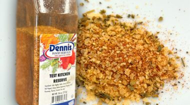 Bottle of Dennis Food Service spice over spice on white plate