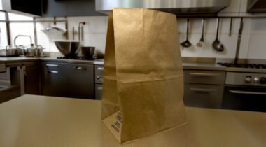 brown paper bag on table in kitchen setting