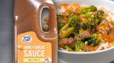 Jug of Brown colored Honey Garlic sauce over bowl of steak, broccoli and white rice with sauce drizzled over