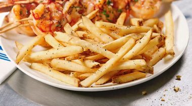 white plate with pile of cooked, seasoned french fries