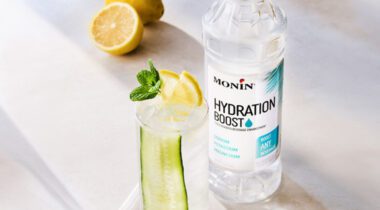 glass of cucumber lemon mint water next to clear bottle of Monin Hydration Boost