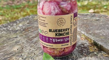 glass jar of Blueberry Kimchi on tree stump