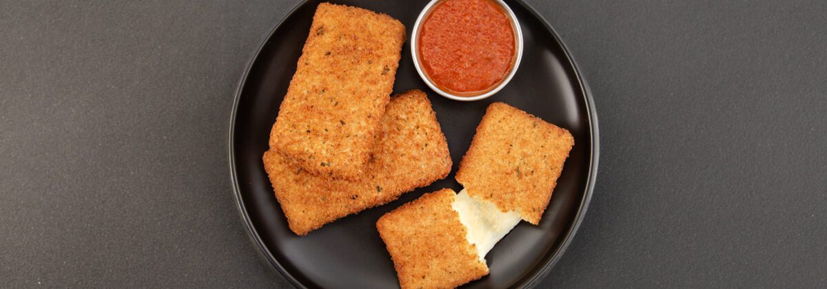 black plate with three mozzarella planks and red dipping sauce
