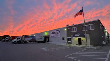 warehouse building with trucks and american flag at sunset