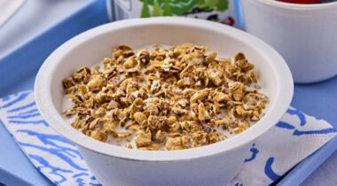 white bowl of granola cereal with milk