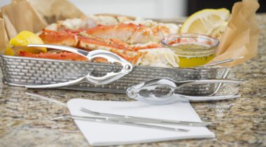 photo of metal lobster crackers in front of a basket of seafood