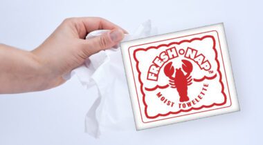 graphic lobster themed wet nap packaging, hand holding towelette