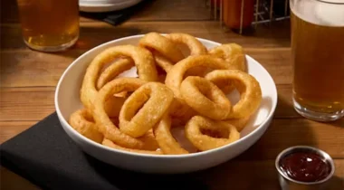 battered onion rings in a bowl on a restaurant table